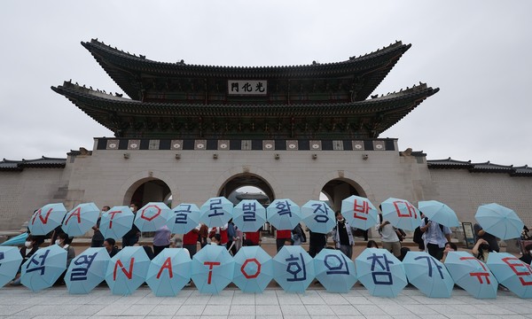 사진: 한국인들이 6월 29일 윤석열 대통령의 NATO 정상회의 참석에 항의하기 위해 서울 경복궁에 모여 있다.