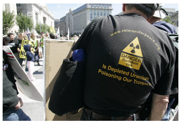 사진: 한 반전 시위자가 2007년 9월 15일 워싱턴에서 열린 이라크전쟁의 종식과 미군의 귀환, 조지 W. 부시 미국 대통령의 탄핵을 요구하기 위해 백악관에서 미국 의사당까지 행진하며 미국 무기에 열화우라늄 사용을 의심하는 티셔츠를 입고 있다.